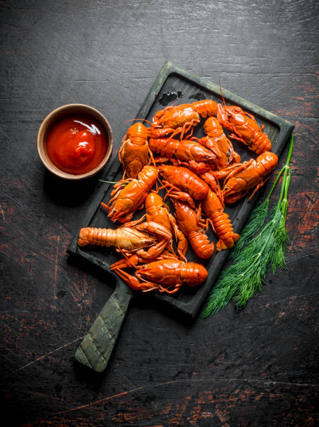 istock Boiled red crayfish on a cutting Board with sauce and dill. 1156107080