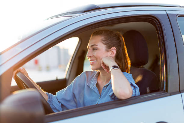 istock Woman driving car in the sunset 1156109541
