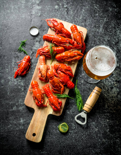 istock Red boiled crayfish on a cutting Board with beer. 1156109595