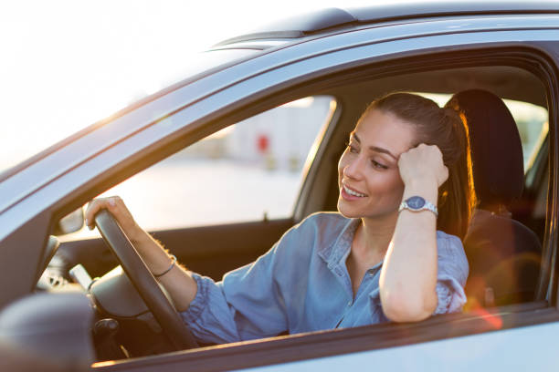 istock Woman driving car in the sunset 1156109683