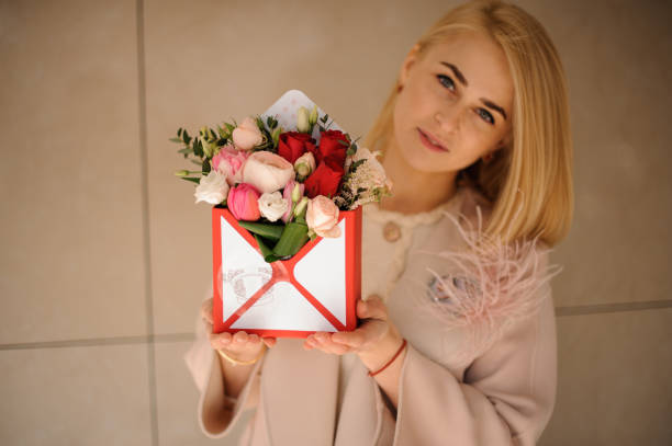 istock Girl with bouquet in a gift box 1156110278