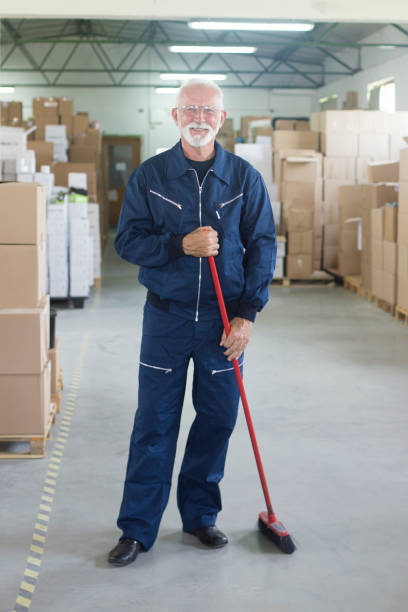 Smiling janitor Janitor cleaning a warehouse. About 60 years old, Caucasian senior male. custodian stock pictures, royalty-free photos & images