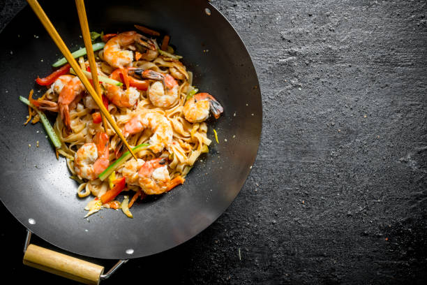 istock Chinese Udon noodles in a wok pan with chopsticks. 1156112504