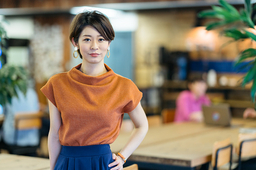 A portrait of a young business woman in a modern co-working space.