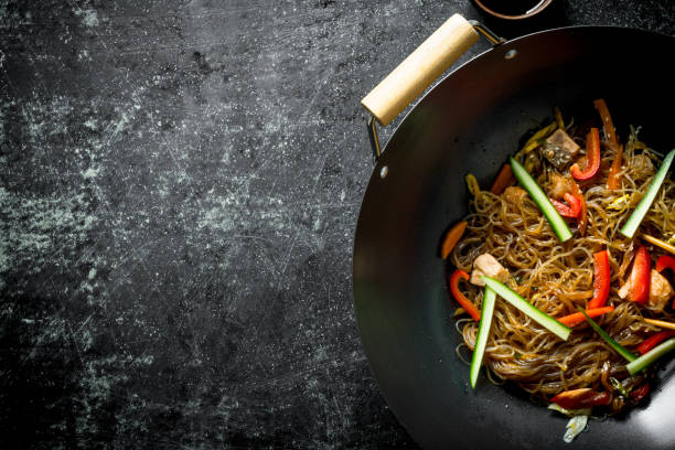 chinese wok. asian cellophane noodles with vegetables and chicken in a frying pan wok. - 1599 imagens e fotografias de stock