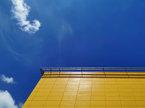 Yellow Tiled Building Exterior Against Blue Cloudy Sky