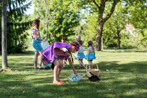istock Educator and kids cleaning garbage from a park 1156115630