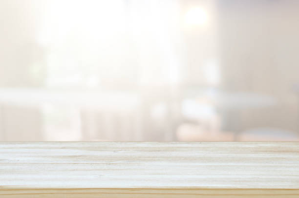 istock image of wooden table in front of abstract blurred window light background 1156122223