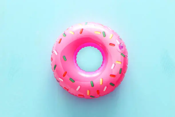 Photo of Inflatable donut ring over blue wooden background