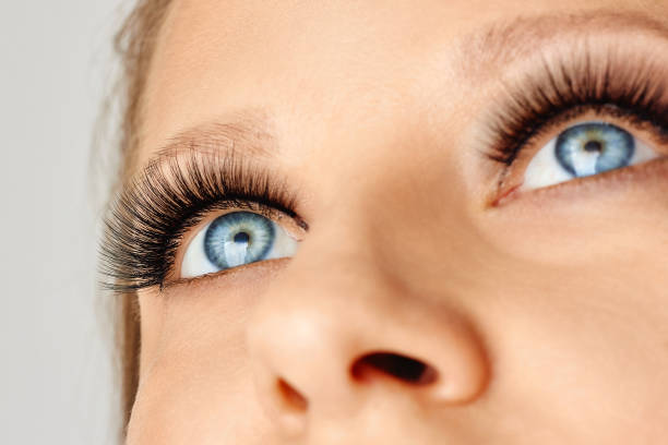 istock Female face with blue eyes with long false eyelashes 1156132267