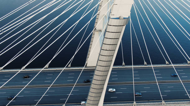 istock flycam moves above modern pylons of long cable-stayed bridge 1156132490