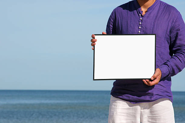 istock Man with blank board at the beach 115613648
