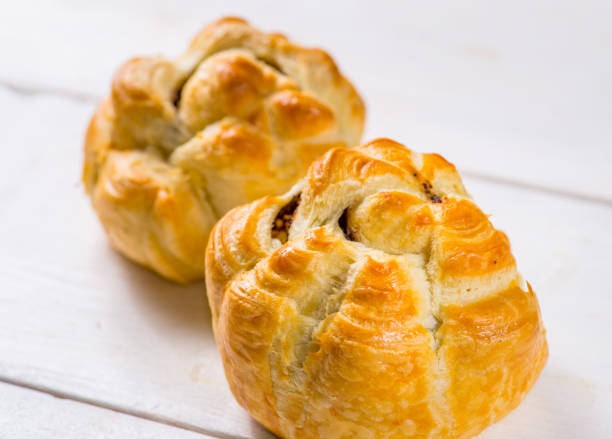 istock Fresh pastries on a white background close-up. Several rolls with filling on a white background 1156137303