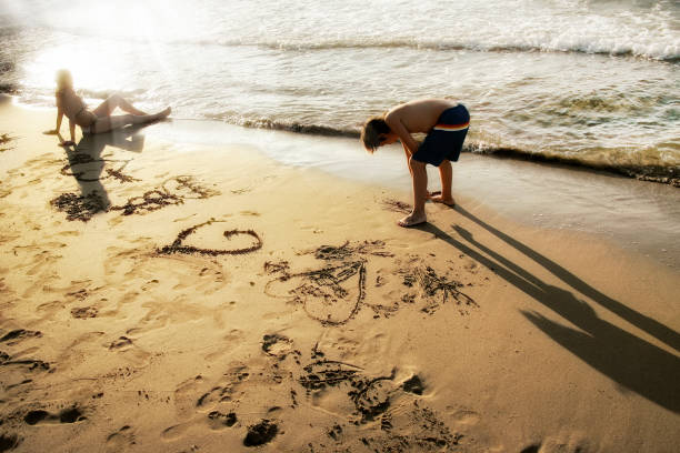 istock close up mother and child playing on gold colored sandy beach 1156138541