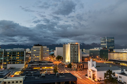 A night view of Anchorage Alaska with mountain range off in the distance.