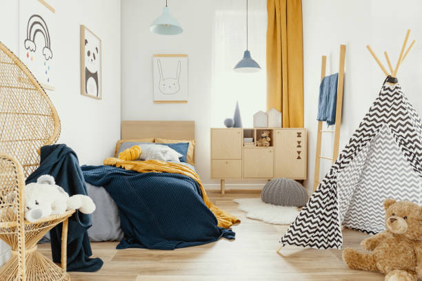 стильный деревянный комод в ярком интерьере спальни с плакатом на стене - childrens furniture стоковые фото и изображения