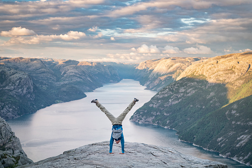 Athletic man pressing a handstand on top of the famous Preikestolen Pulpit Rock, Norway. Nikon D850. Converted from RAW.
