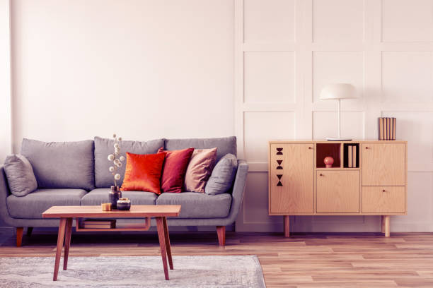 istock Vintage wooden commode next to grey Scandinavian sofa with pillows 1156144621