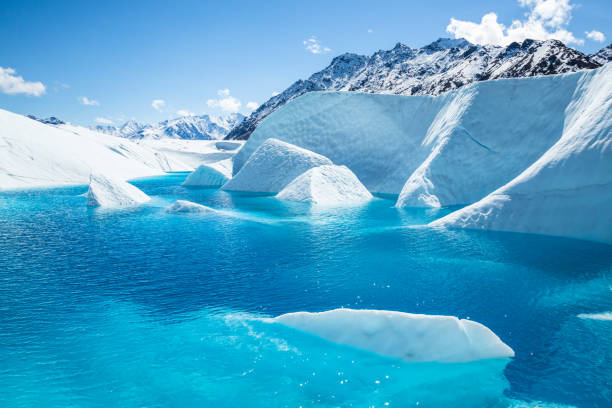 mount wickersham over a large blue pool with fins of ice protruding from the cold waters. - lake mountain range mountain deep imagens e fotografias de stock