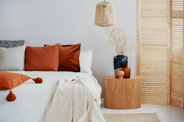 istock Dark orange and grey pillow on king size bed, copy space on empty wall 1156144830