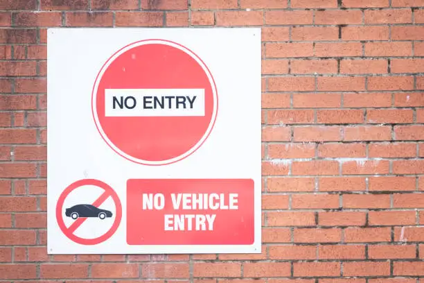No vehicle entry sign on red brick wall uk