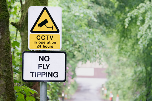 No fly tipping sign in beautiful landscape garden uk