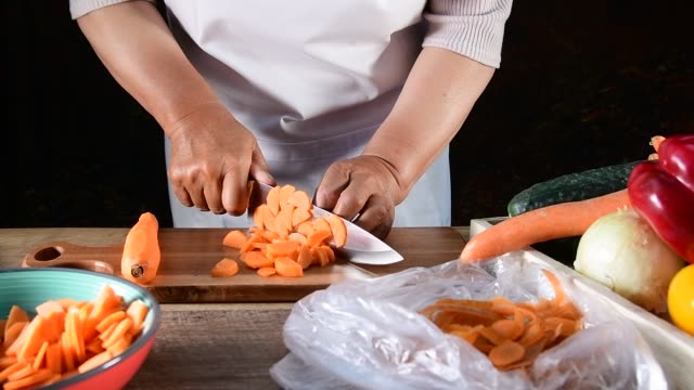 Woman slicing carrots on the cutting board