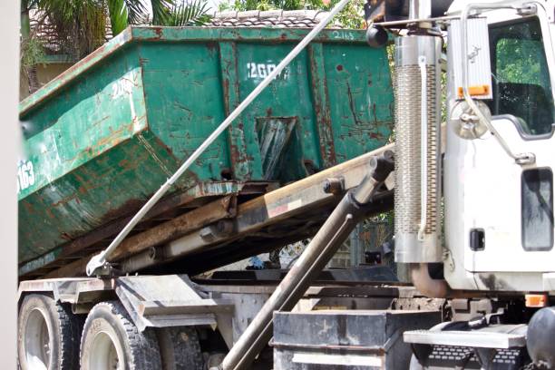istock Full roll-off dumpster being loaded on removal truck 1156160801