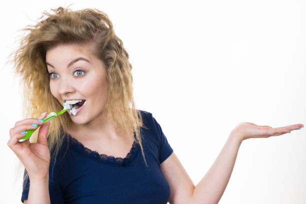 istock Woman brushing teeth holds open hand 1156160912