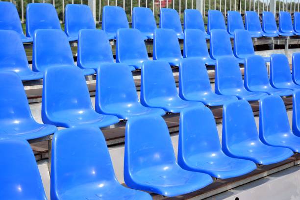 istock Empty blue plastic chairs in a row at the football stadium 1156162196