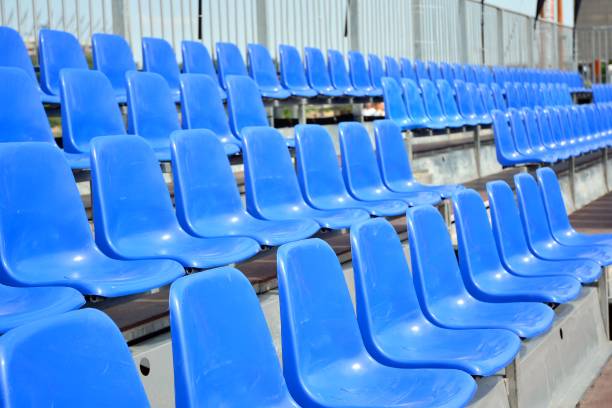 istock Empty blue plastic chairs in a row at the football stadium 1156162230