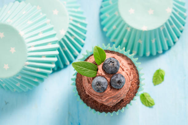 fresh  muffins with blueberry and mint on wooden background