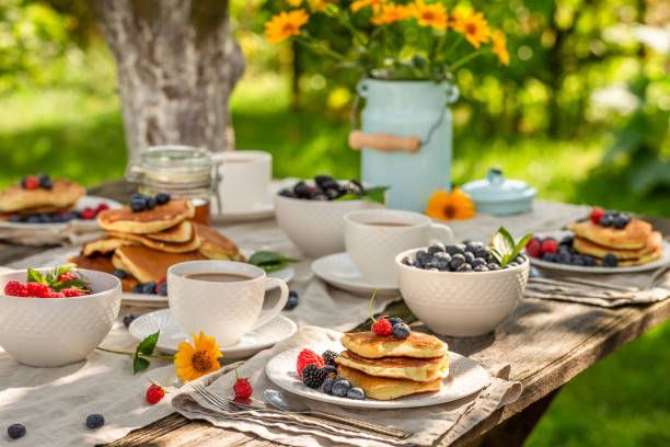 Homemade pancakes served with coffee in summer garden stock photo