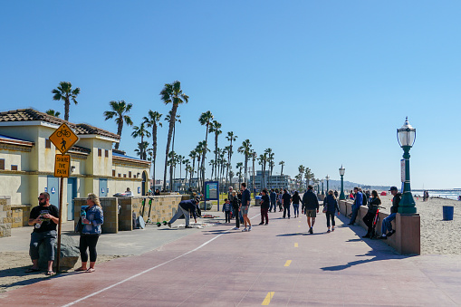 The Mission Beach boardwalk, a concrete walkway shared by walkers and bicyclists. famous tourist destination with bar & restaurant next the beach. San Diego, California, USA.