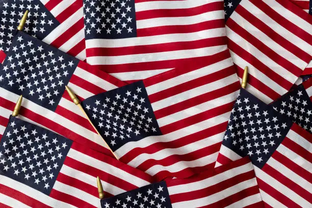 Patriotic Background - Large pile of American Flags background.  Fourth of July, Memorial Day, Veterans Day, US Election concept background.