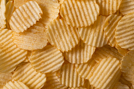 Pile of potato chips, a junk food background.