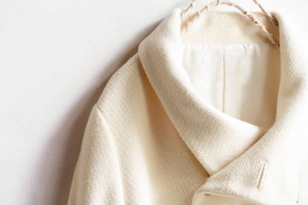 istock white wool coat hanging on clothes hanger on white background 1156180350