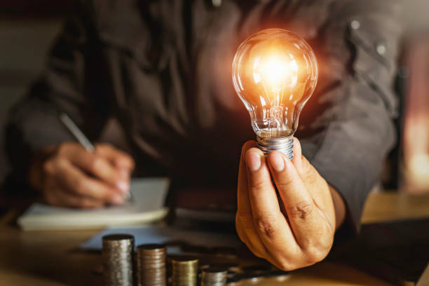 istock businessman holding light bulb with money stack.saving energy power concept 1156182325