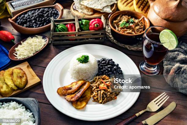 Venezuelan Traditional Food Pabellon Criollo With Arepas Casabe And Papelon With Lemon Drink Stock Photo - Download Image Now
