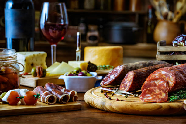 素朴な木製のテーブルの上にチーズ、硬化ハム、サラミワイン、チョリソのタパス - wine bottle food wine restaurant ストックフォトと画像