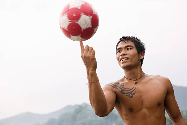 guy spinning football on finger - indonesia football stok fotoğraflar ve resimler