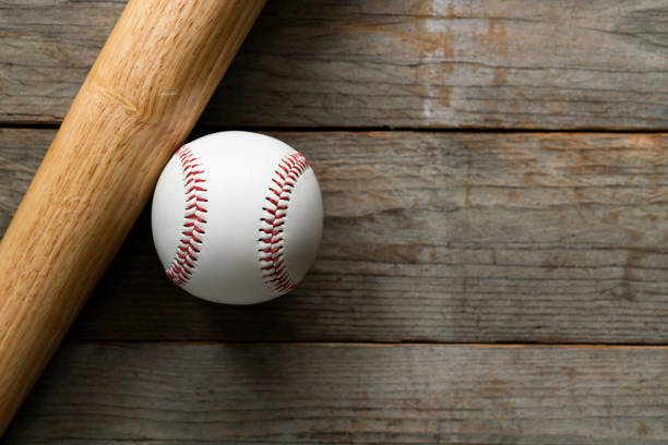istock baseball and baseball bat on wooden table background 1156193597