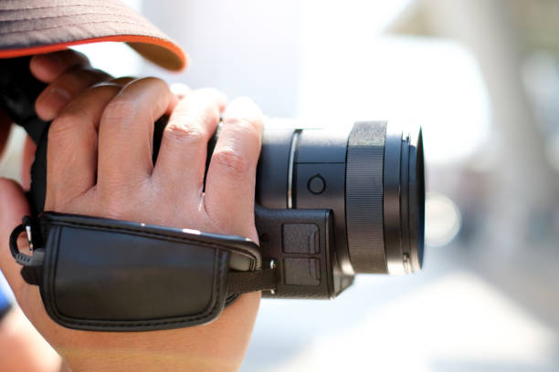 istock The young man holds a camera  to record motion pictures. 1156193613