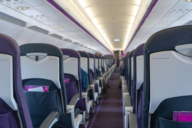 seats in the airplane and passenger sitting all area waiting for the plane taking off from runway.