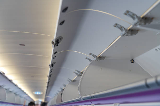 istock Carry-on luggage in overhead storage compartment on commercial airplane 1156197882