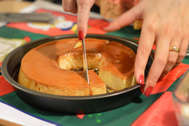 Close-up of a lady slicing a creme caramel pudding