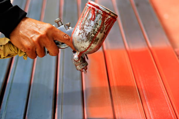 People are spraying a primer with steel to prevent rust. People are working with spray paint to prevent rust. airless stock pictures, royalty-free photos & images