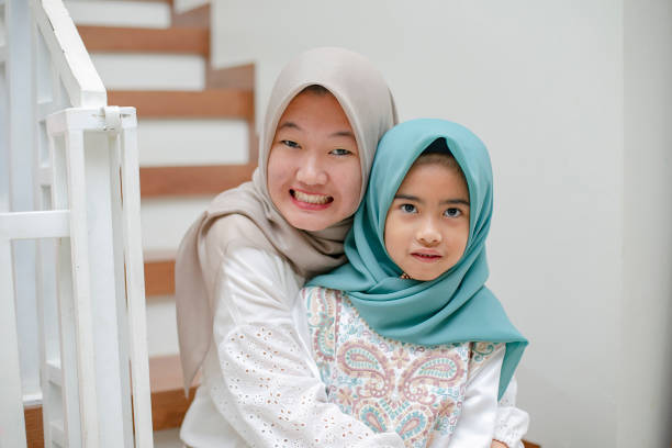 istock a mother assist her kid using hijab in lebaran (eid-ul-fitri) celebration 1156201651