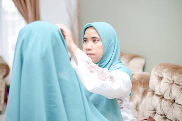 istock a mother assist her kid using hijab in lebaran (eid-ul-fitri) celebration 1156201774