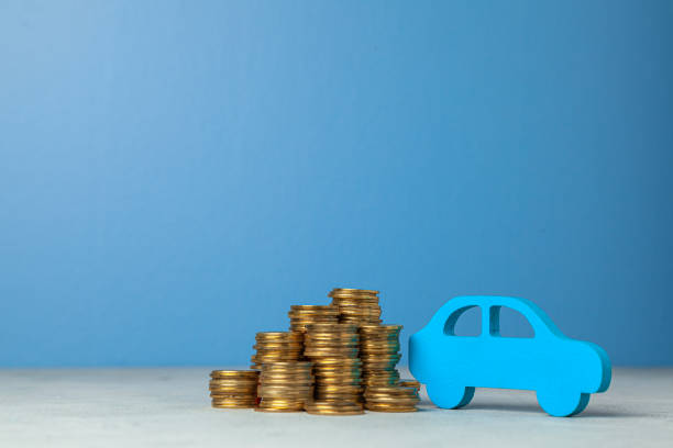 istock Car and a stack of coins. Concept car purchase or insurance. Blue background. 1156204714